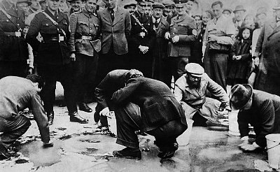 Judíos ancianos limpiando la calle ante la mirada de la policía (Viena, 1938)