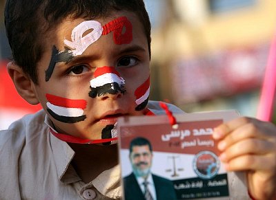 Un niño egipcio mantiene una imagen del candidato presidencial de la Hermandad Musulmana, Mohammed Morsi (junio de 2012)