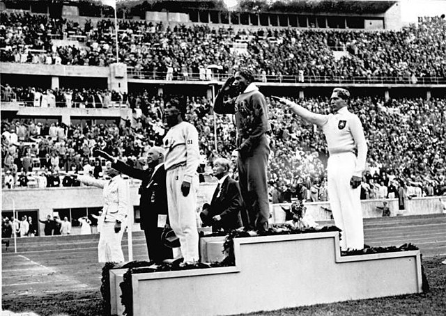 Jesse Owens en el podio olímpico después de su victoria en el salto de longitud en los Juegos Olímpicos de Berlín 1936.