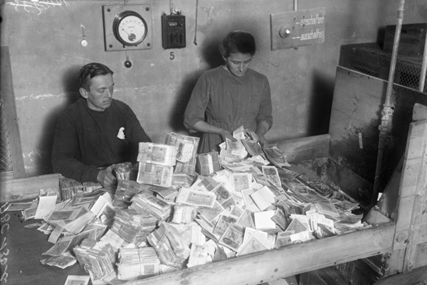 Funcionarios alemanes recolectando el papel moneda devaluado, 1924.