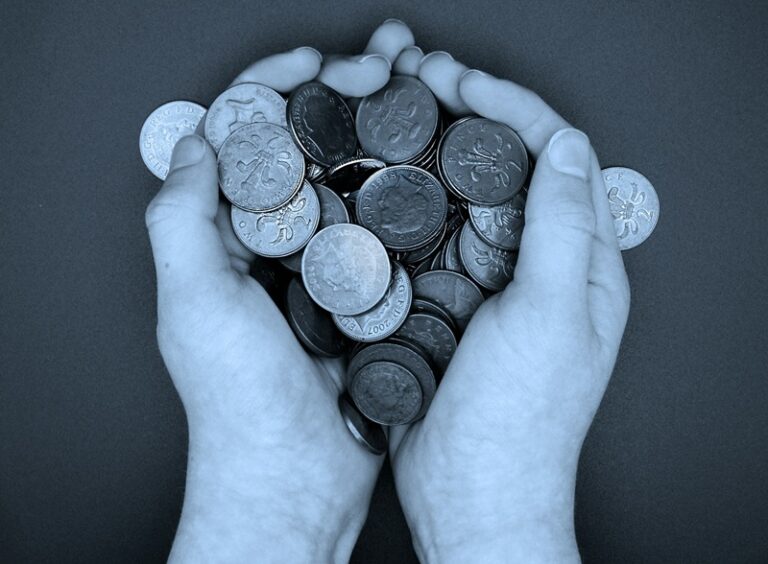 Una persona sosteniendo un montón de monedas en sus manos. Imagen de Richard Rjack